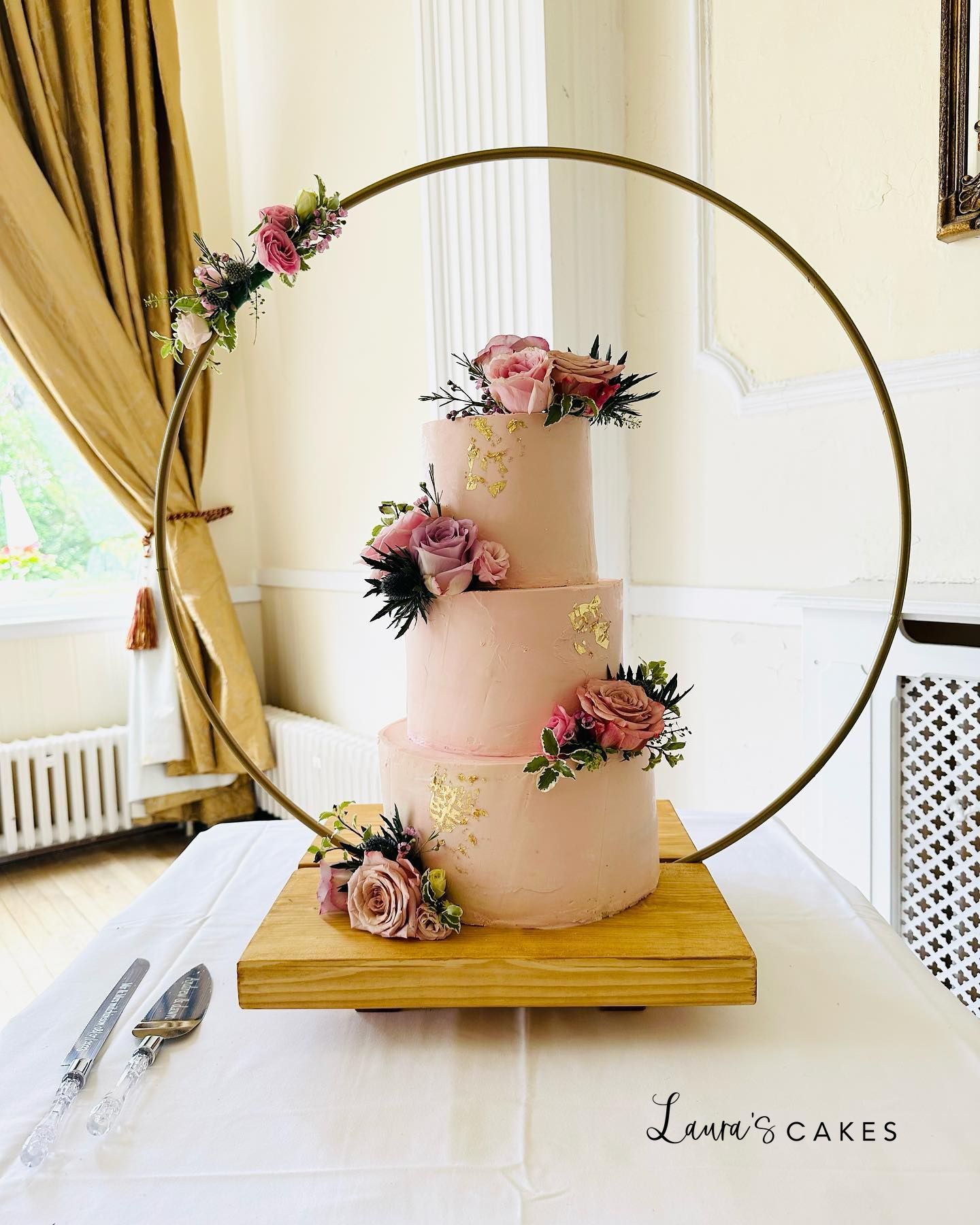 1-a-pink-cake-with-flowers-on-a-wooden-stand