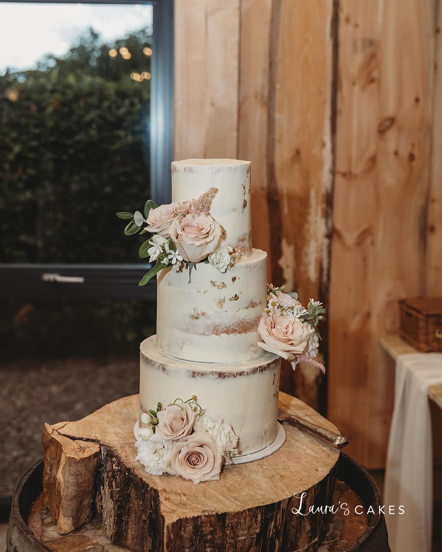 1-a-white-wedding-cake-with-pink-flowers-on-a-tree-s