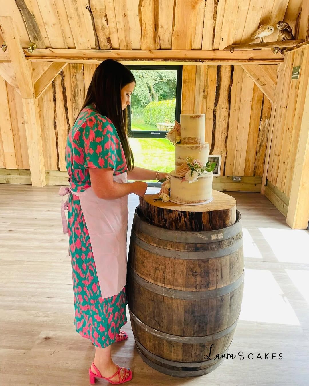 1-a-woman-standing-next-to-a-barrel-with-a-cake-on-i