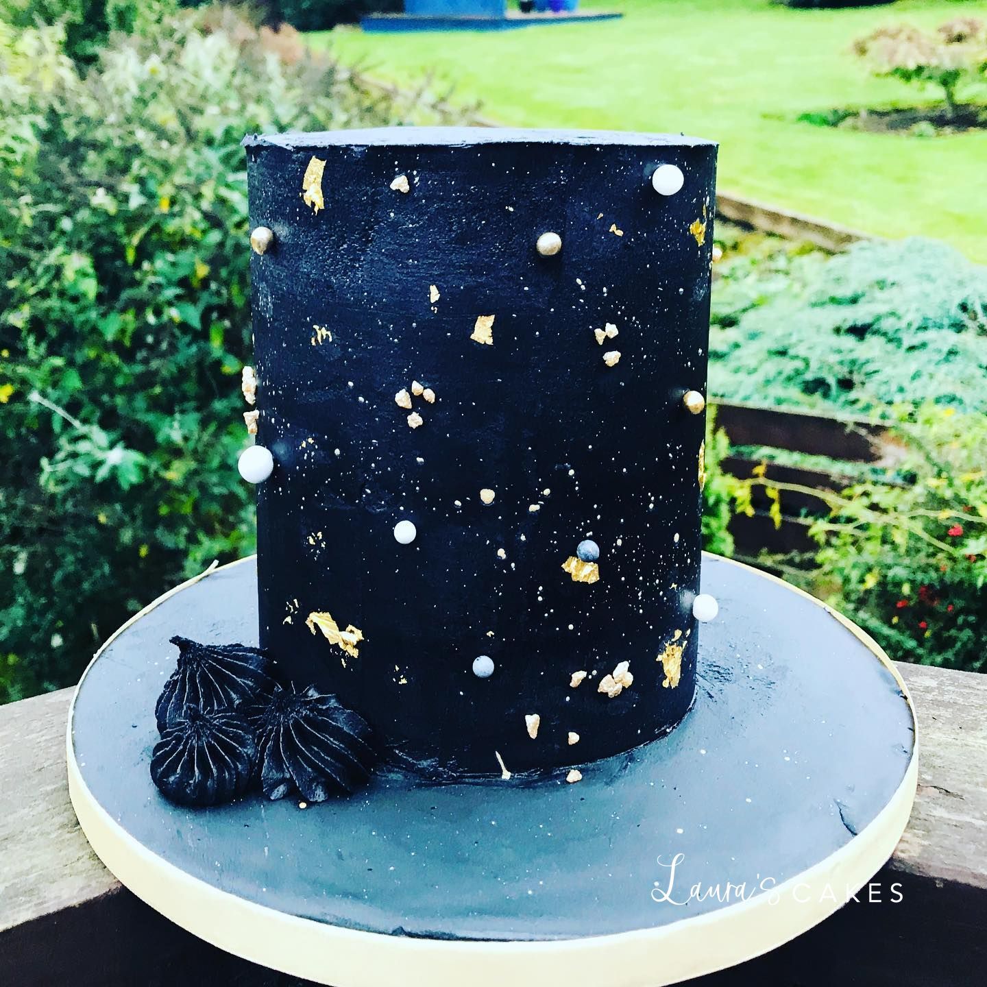 Celebration cake: A black and gold cake with gold decorations