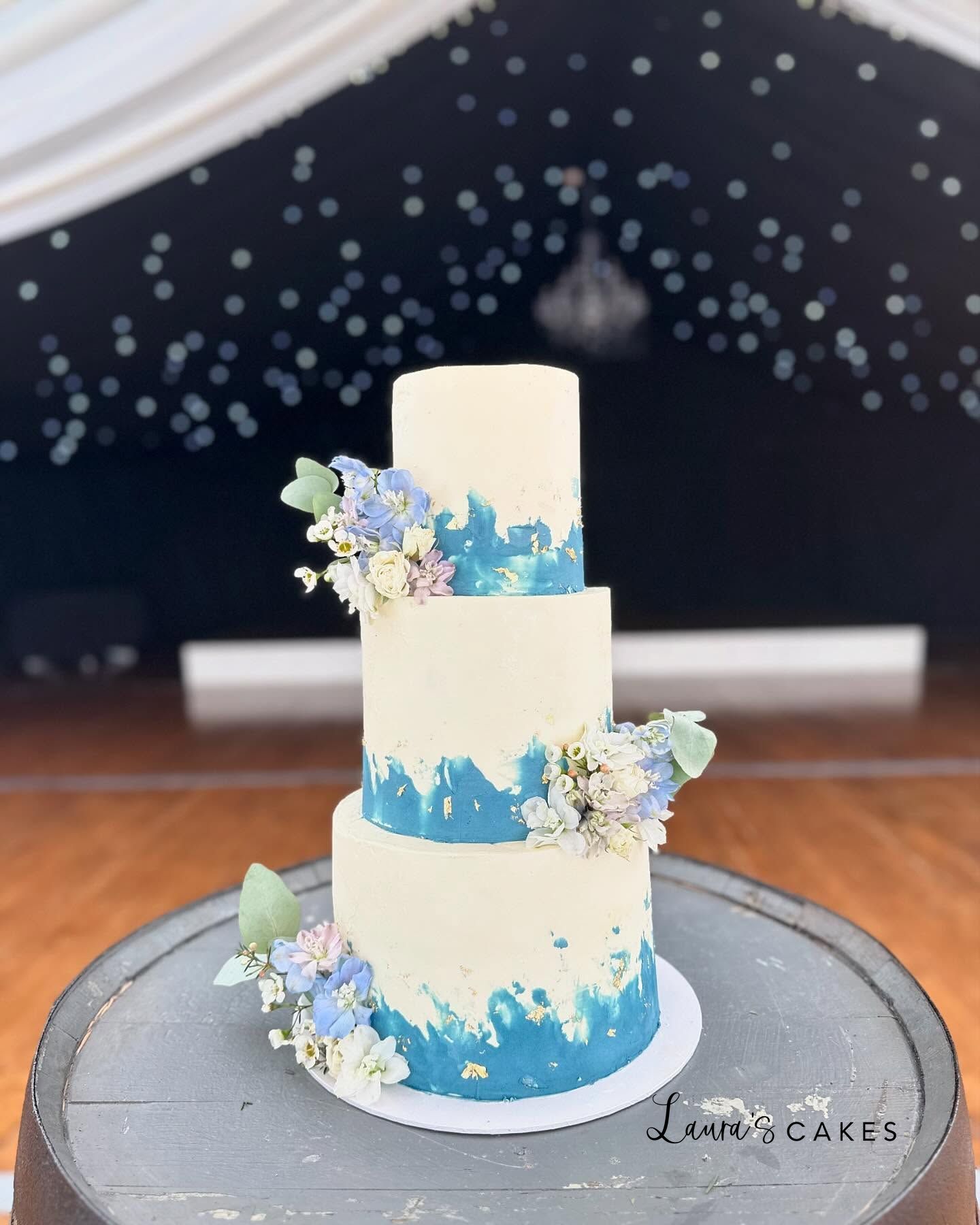 Wedding cake: A blue and white wedding cake with flowers on top