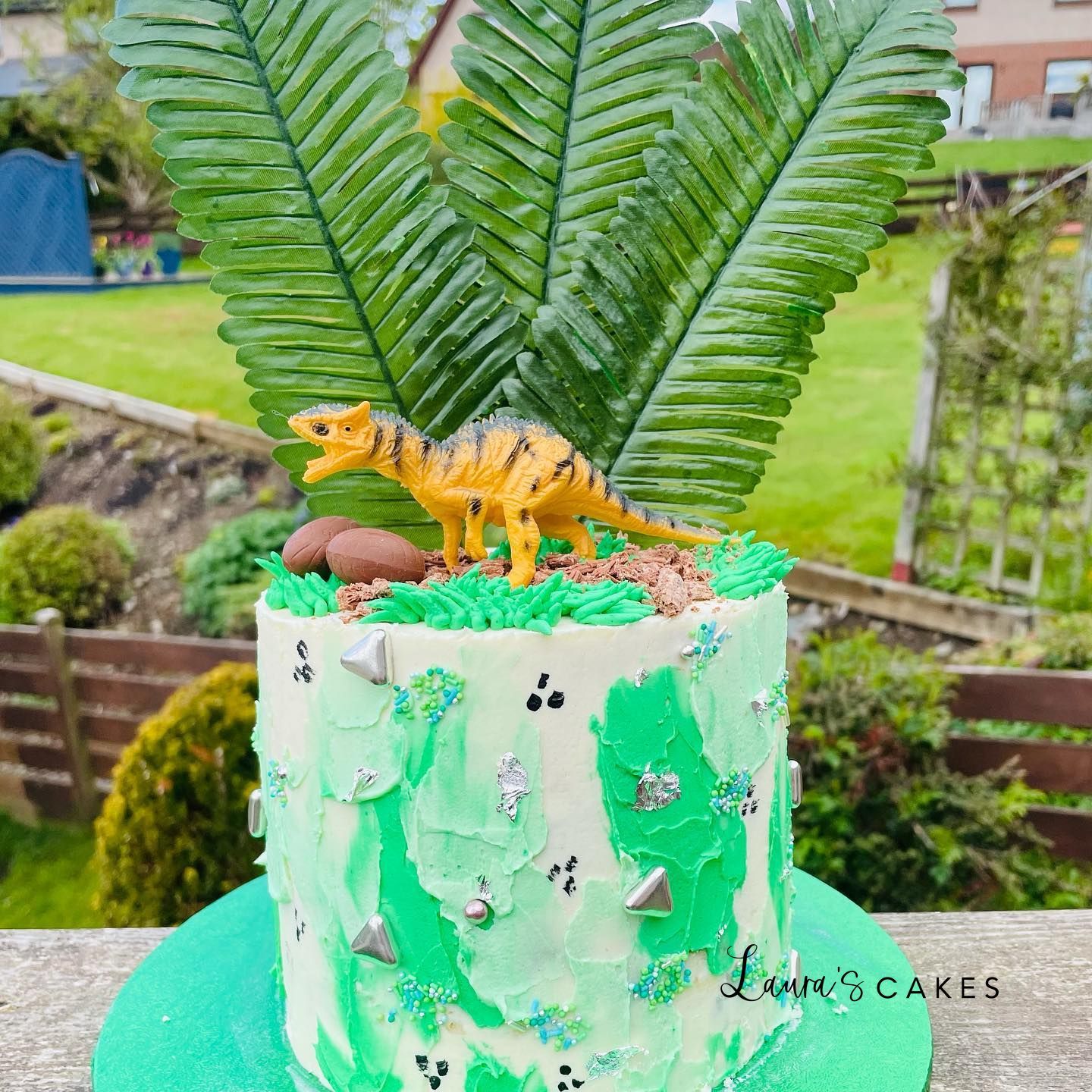 Celebration cake: A dinosaur cake with a green frosting and a green leaf