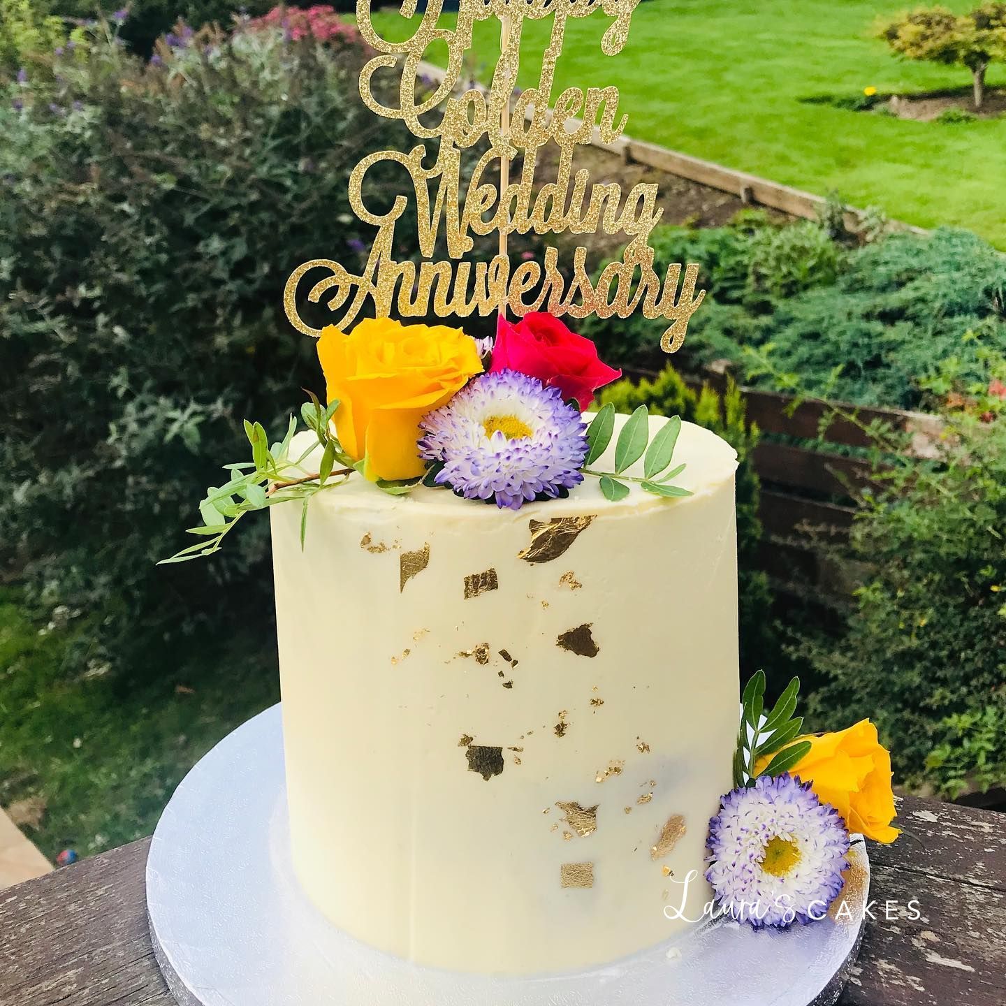 Celebration cake: A gold cake topper and flowers