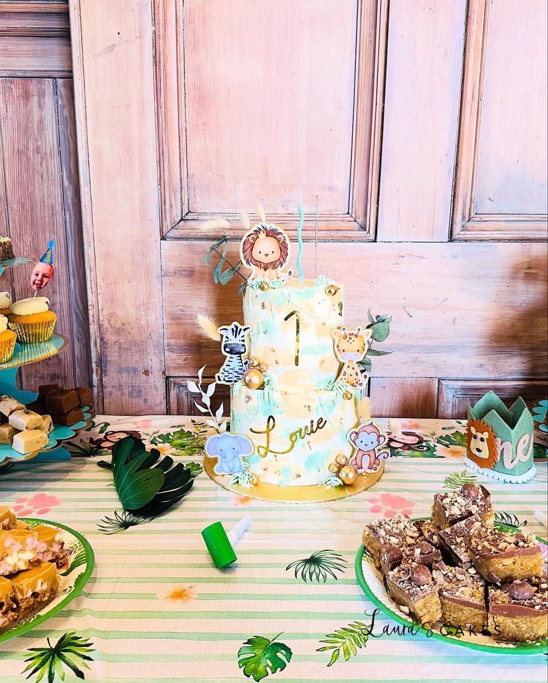 Celebration cake: A table with a cake and cupcakes on it