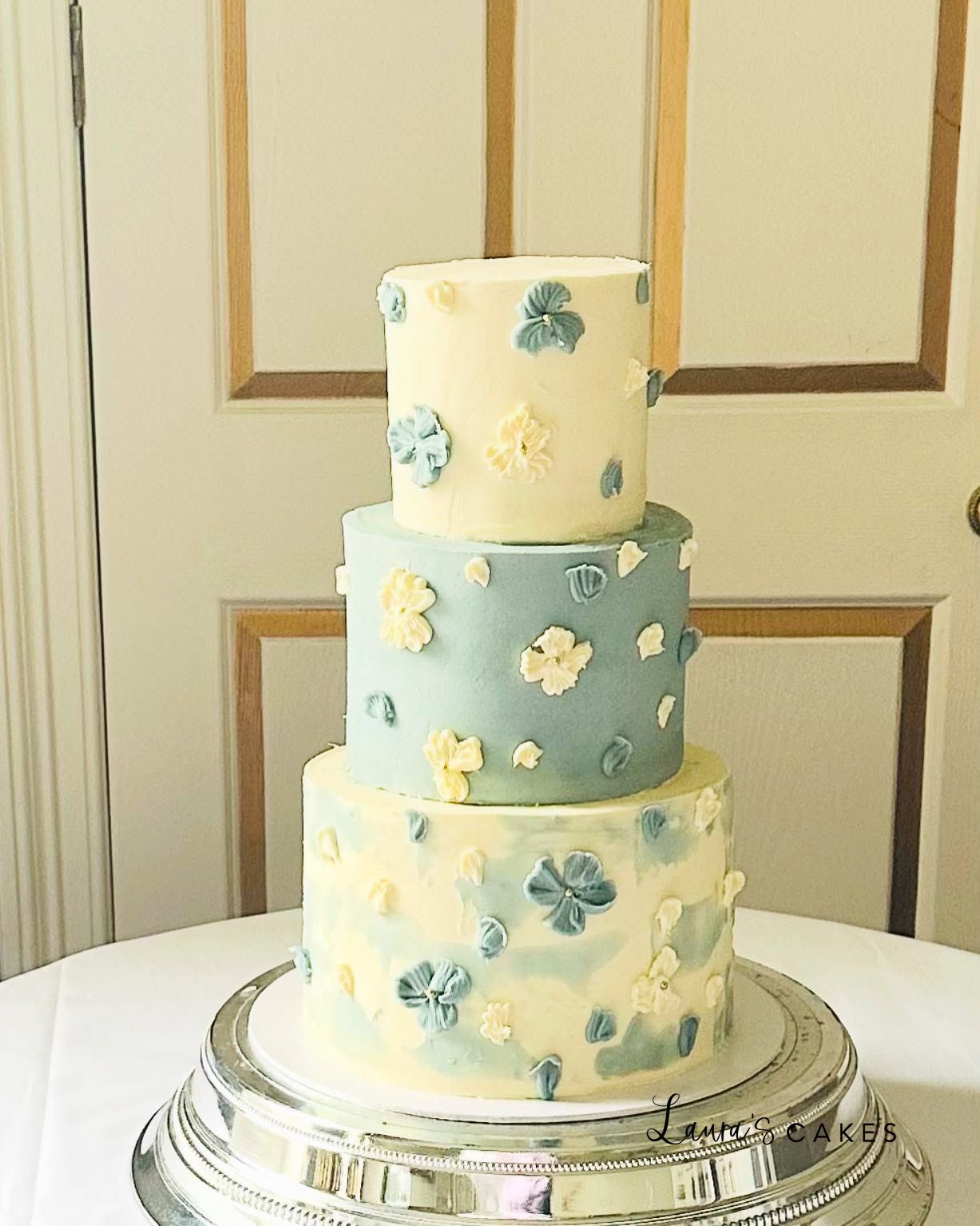 Wedding cake: A three tier cake with blue and yellow flowers