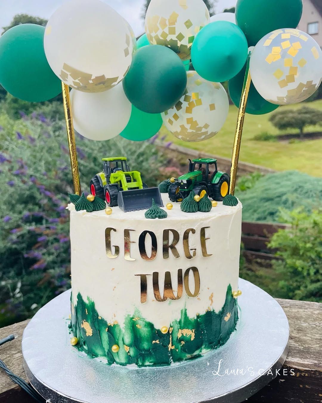 Celebration cake: A tractor cake with green and gold balloons