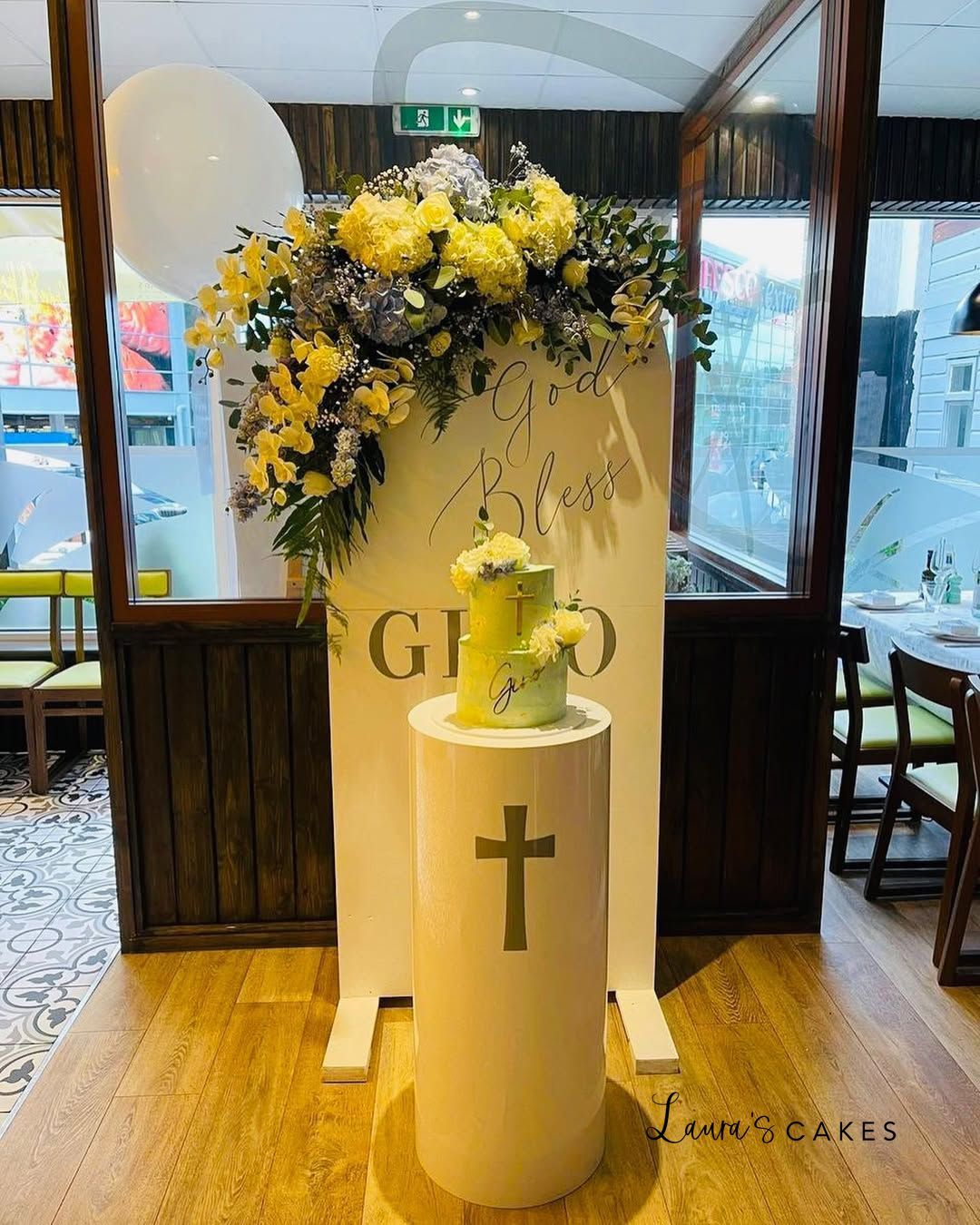 Celebration cake: A vase with flowers and a cross on it