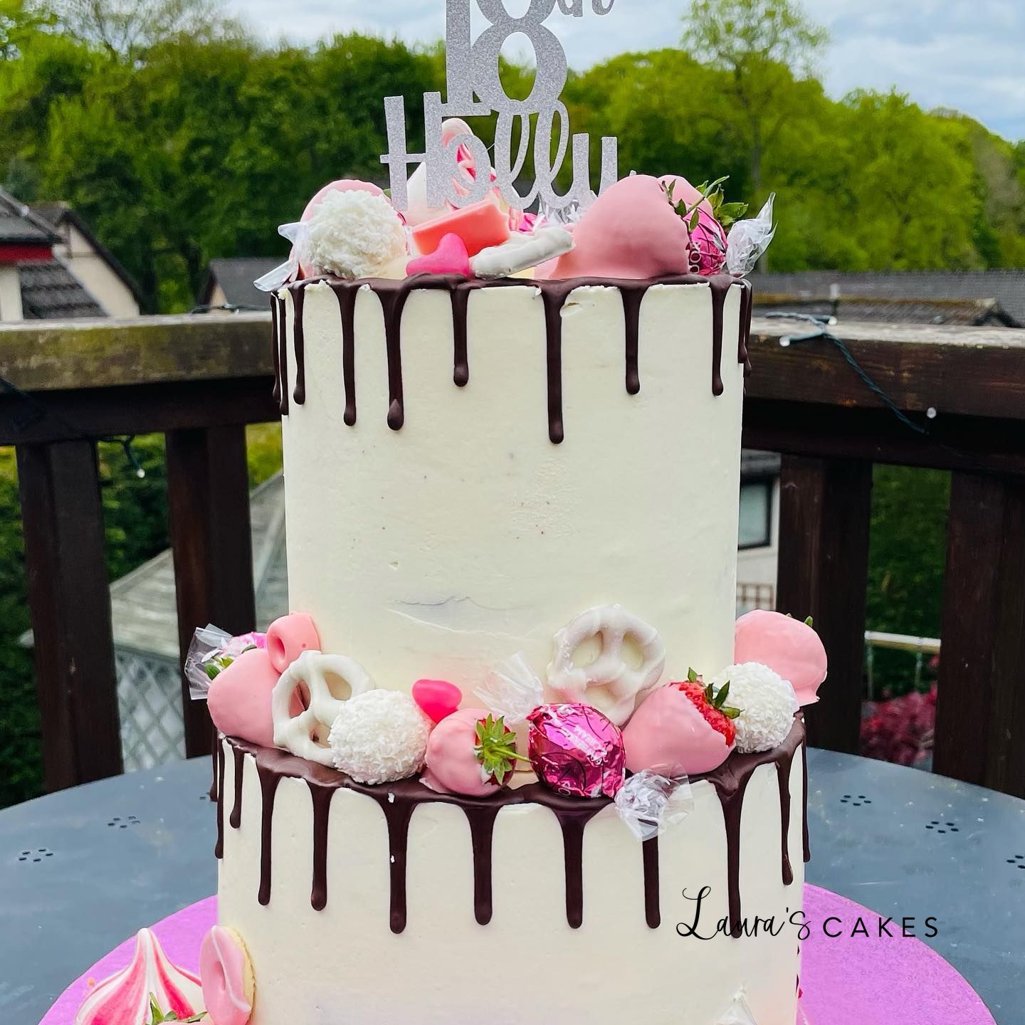 Celebration cake: A white cake with chocolate drips and pink flowers