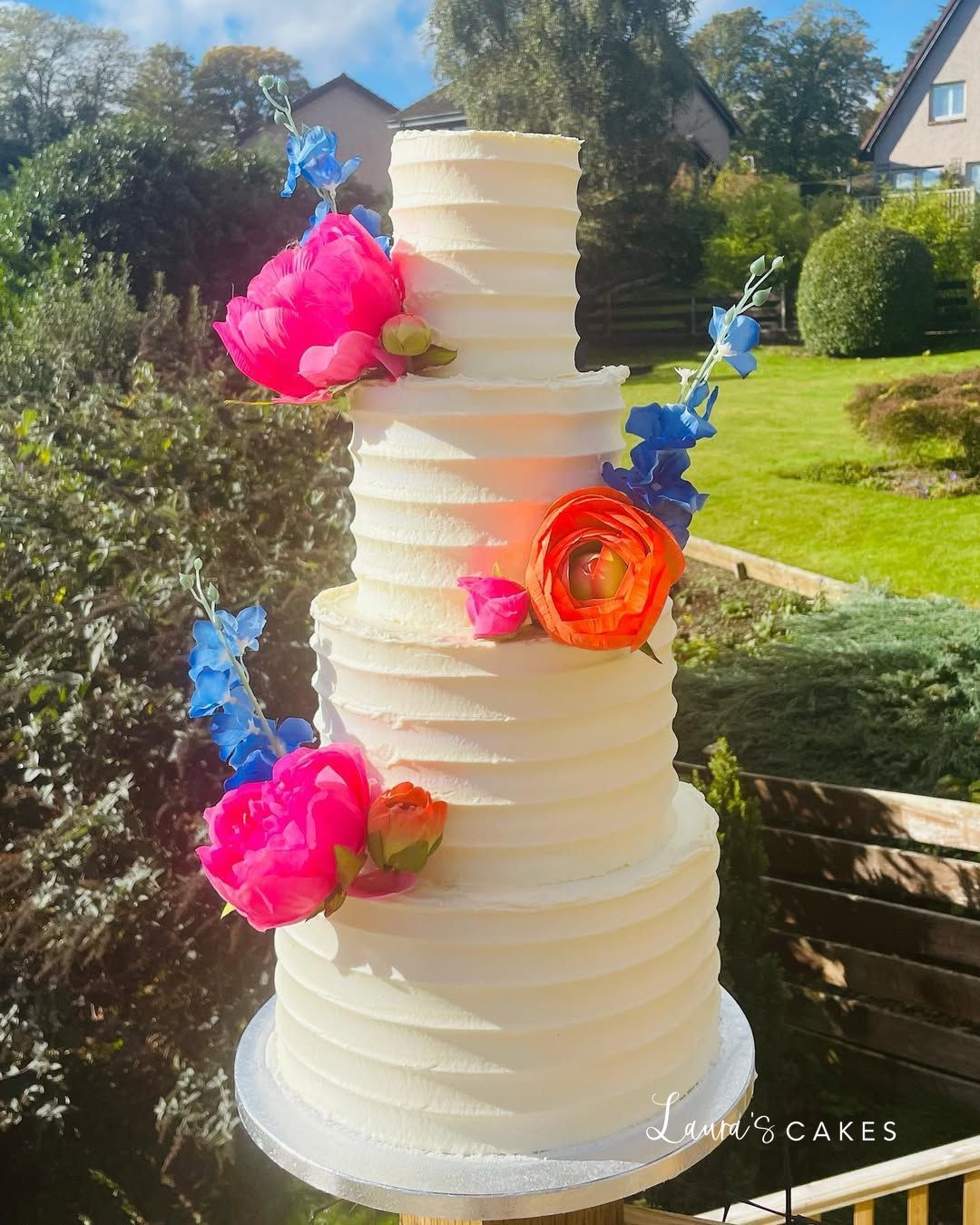 Wedding cake: A white cake with pink and blue flowers on top