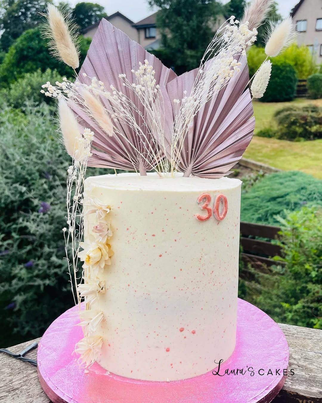Celebration cake: A white cake with pink and white feathers on top