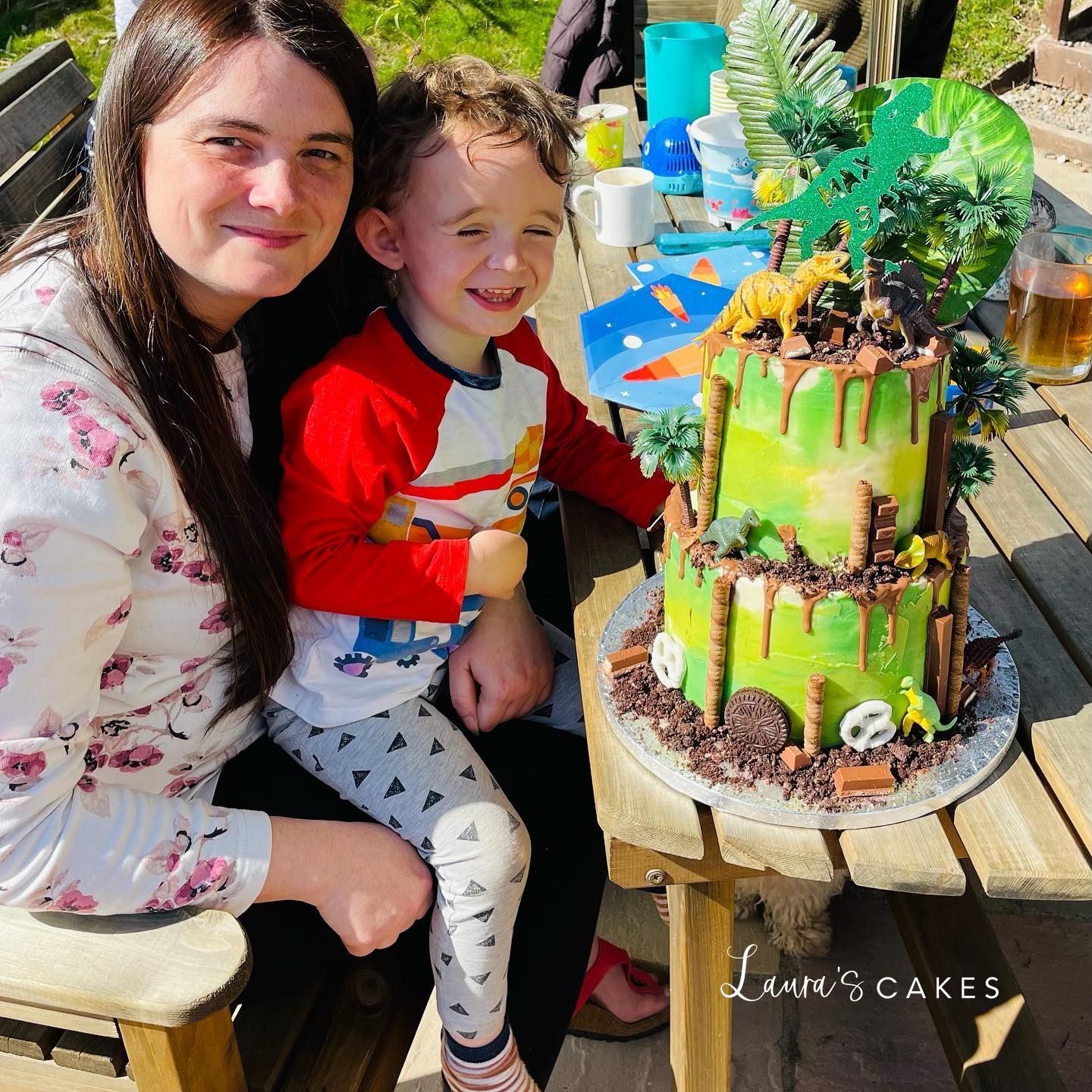 Celebration cake: A woman and a child sitting at a table with a cake