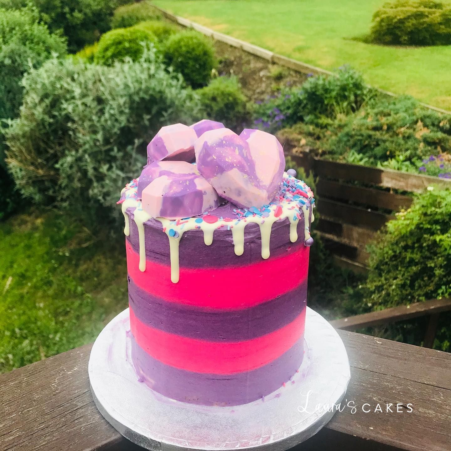 Celebration cake: Purple and red frosting on a table