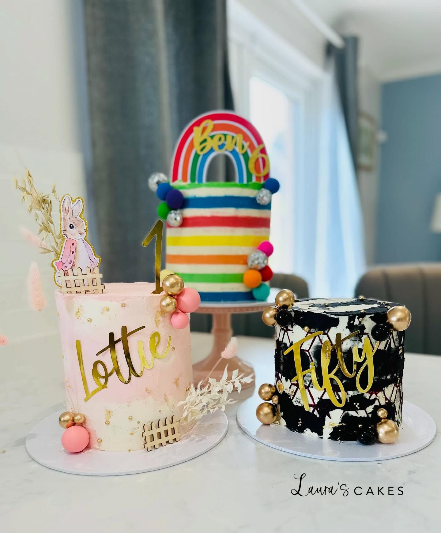 Celebration cake: Two cakes with gold letters and a rainbow cake